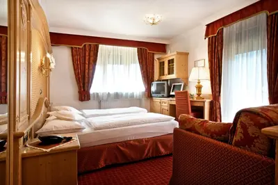 a hotel room with a bed and a desk at B&B Garni Serena in Arabba