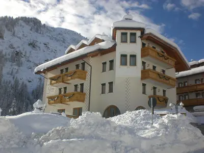 a building with a pile of snow in front of it at B&B Garni Serena in Arabba