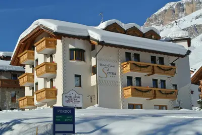 a building with a sign in front of it in the snow at B&B Garni Serena in Arabba