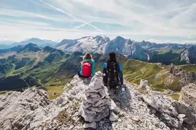 a woman sitting on the edge of a mountain at Active Hotel Malita in Arabba