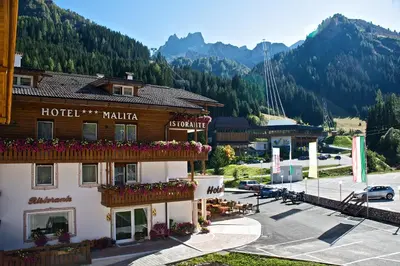 a hotel in the mountains with a parking lot at Active Hotel Malita in Arabba