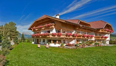 a house on a hill with flowers on it at Residence Sonnwies in Valdaora