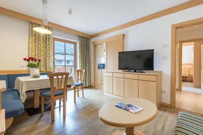 a living room with a dining table and a television at Residence Sonnwies in Valdaora