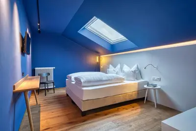 a bedroom with a bed with a blue ceiling at Oberwirt Weisses Kreuz in Collepietra