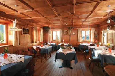 a dining room filled with tables and chairs with tablesearcher at Oberwirt Weisses Kreuz in Collepietra