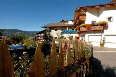 a wooden fence in front of a building at Oberwirt Weisses Kreuz in Collepietra