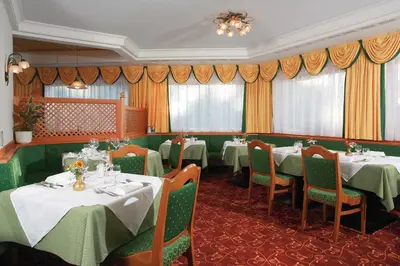 a dining room with tables and chairs and curtains at Oberwirt Weisses Kreuz in Collepietra