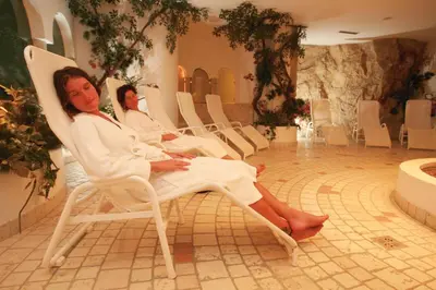 two people sitting in white chairs in a room at Oberwirt Weisses Kreuz in Collepietra