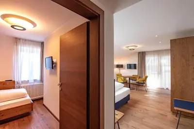 a hotel room with a bed and a table at Oberwirt Weisses Kreuz in Collepietra