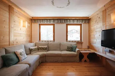 a living room with a couch and a tv at BelaVal Apartments in La Villa