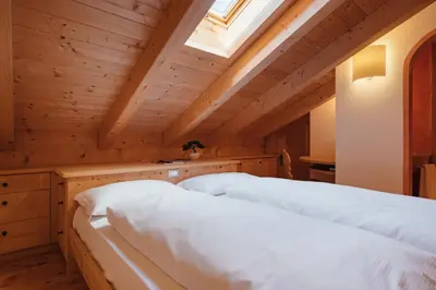 two beds in a room with a skylight at BelaVal Apartments in La Villa