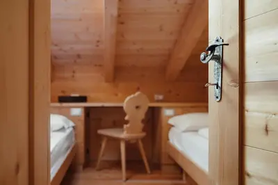 a small room with a bed and a chair at BelaVal Apartments in La Villa
