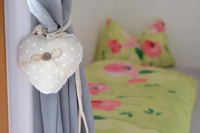 a curtain with a heart on it next to a bed at Ferienwohnungen Villa Mirabilis in Rablà
