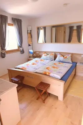 a bedroom with a large bed with a large mirror at Ferienwohnungen Villa Mirabilis in Rablà