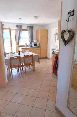 a kitchen and dining room with a table and chairs at Ferienwohnungen Villa Mirabilis in Rablà