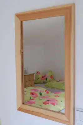 a mirror reflection of a bed in a bedroom at Ferienwohnungen Villa Mirabilis in Rablà