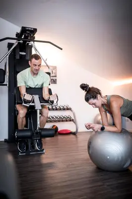 a man and a woman working out in a gym at Hotel Alpenhof in Rasùn di Sotto
