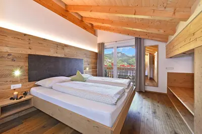 a bedroom with a large bed in a wooden wall at Jaiterhof in Funes