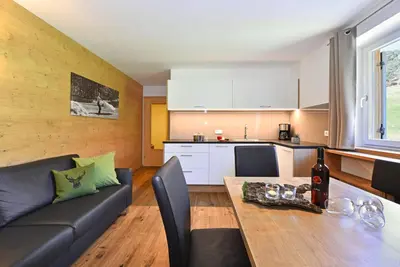 a kitchen and a living room with a couch and a table at Jaiterhof in Funes