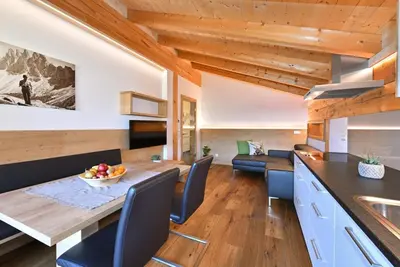 a kitchen and living room with a wooden ceiling at Jaiterhof in Funes
