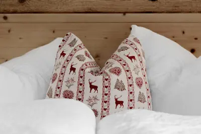 a pair of pillows sitting on top of a bed at Chalet Ciasa Tino & Sara - BelaVal Apartments in Corvara in Badia