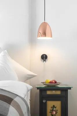 a bed with a table with a plate of fruit on it at Hotel Conturines in San Cassiano