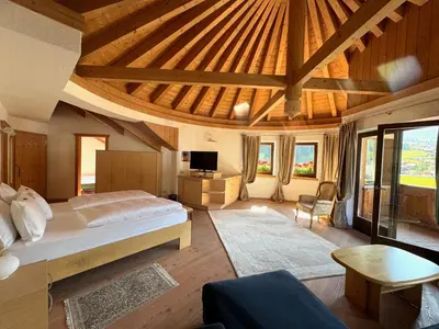 a bedroom with a bed and a couch and a tv at Hotel Table in Corvara in Badia