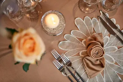 a table with a candle and a flower on it at Hotel Table in Corvara in Badia