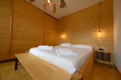 a bedroom with a bed in a wooden wall at Casa Olimpia in Cortina dʼAmpezzo