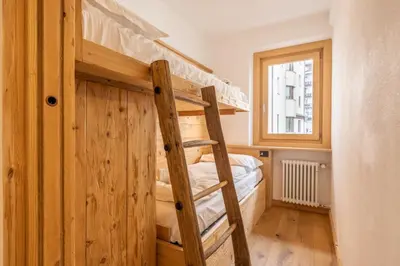 a bunk bed in a room with a ladder at Casa Olimpia in Cortina dʼAmpezzo