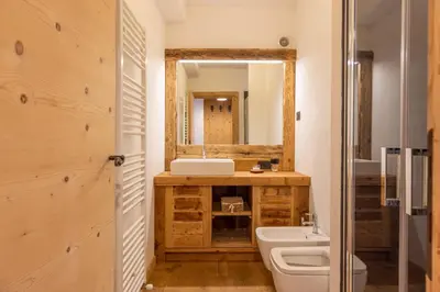a bathroom with a sink and a toilet and a mirror at Casa Olimpia in Cortina dʼAmpezzo