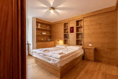 a bedroom with a bed and a ceiling fan at Casa Alverà in Cortina dʼAmpezzo