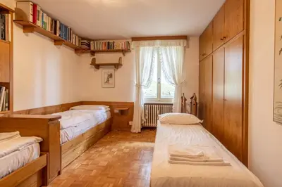 a bedroom with two beds and a window at Casa Alverà in Cortina dʼAmpezzo