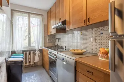 a kitchen with wooden cabinets and a white dishwasher at Casa Alverà in Cortina dʼAmpezzo