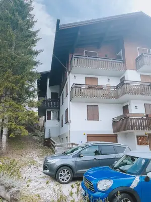 two cars parked in front of a building at Casa Alverà in Cortina dʼAmpezzo