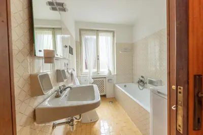 a bathroom with a sink and a tub and a toilet at Casa Alverà in Cortina dʼAmpezzo