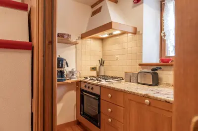 a small kitchen with a stove and a microwave at Casa Do Sol in San Vito di Cadore