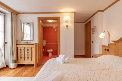a bedroom with two beds and a bathroom at Casa Do Sol in San Vito di Cadore