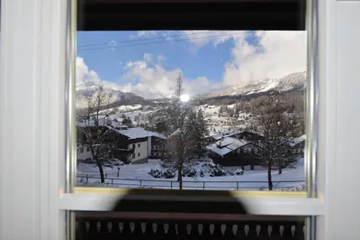 a window with a view of a snow covered mountain at Casa Majon in Cortina dʼAmpezzo