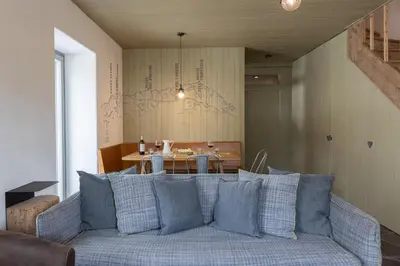 a living room with a blue couch and a table at Casa Majon in Cortina dʼAmpezzo