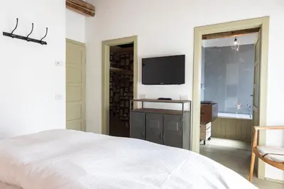 a bedroom with a bed and a flat screen tv at Casa Majon in Cortina dʼAmpezzo