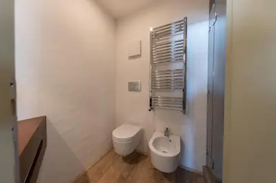 a white bathroom with a toilet and a bidet at Casa Majon in Cortina dʼAmpezzo