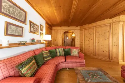 a living room with a red couch and a table at Casa Pecol in Cortina dʼAmpezzo