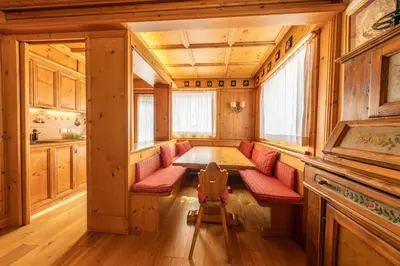 a dining room with a table and red chairs at Casa Pecol in Cortina dʼAmpezzo
