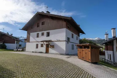 a large white building with a brown roof at Casa Pecol in Cortina dʼAmpezzo