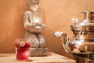 a cup of tea next to a statue of a person at Garnì Sirio in Colfosco