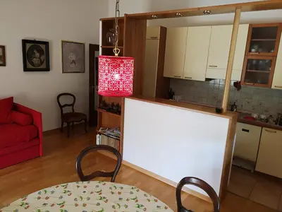 a living room with a table and a red lamp at Spazioso e accogliente nel centro di Merano in Merano