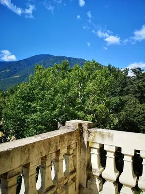 a stone bridge with trees and mountains in the background at Spazioso e accogliente nel centro di Merano in Merano