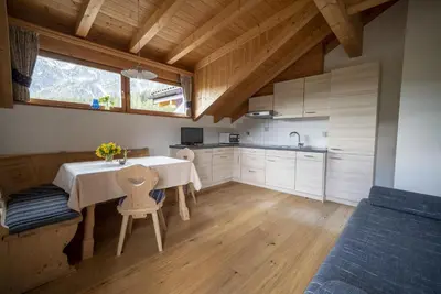a kitchen with a table and chairs in a room at Appartamenti Sotgherdena in Badia