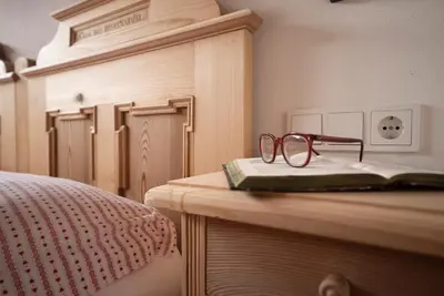 a pair of glasses sitting on top of a bed at Appartamenti Sotgherdena in Badia